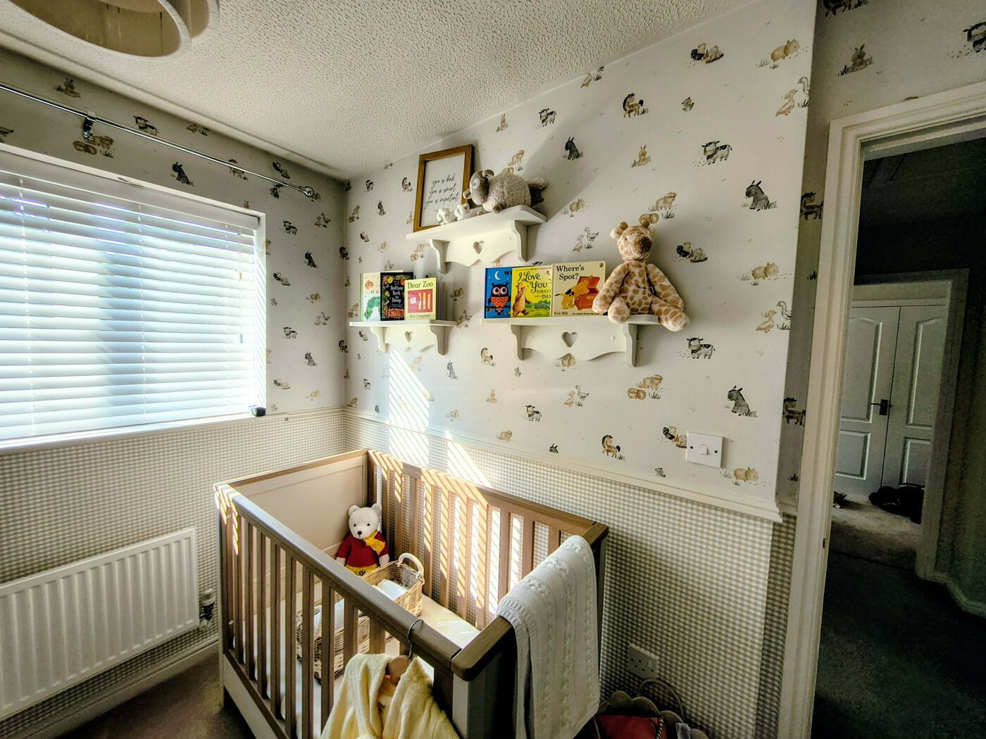 Nursery with farmyard patterned wallpaper above a fitted dado rail and gingham check paper below — the same two-part wallpaper schemes hung for Southport families
