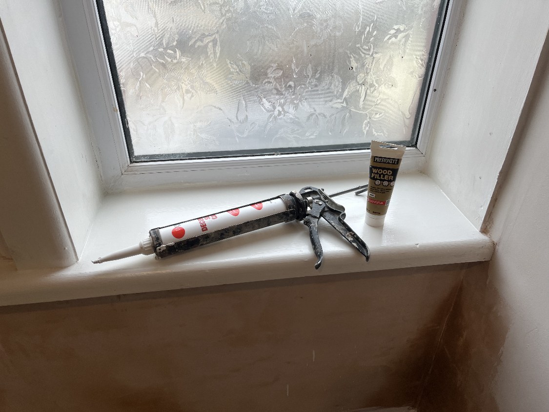 Caulk gun and filler used to repair a cracked joint during a Burnley restoration project